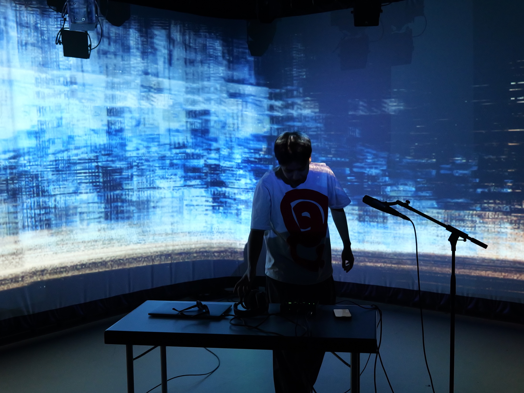 Haoran Wang performing sound in front of the blue projection at STF