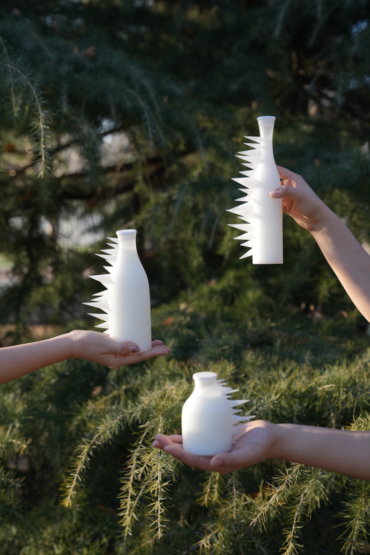 Three spiked bottles held in sunlight