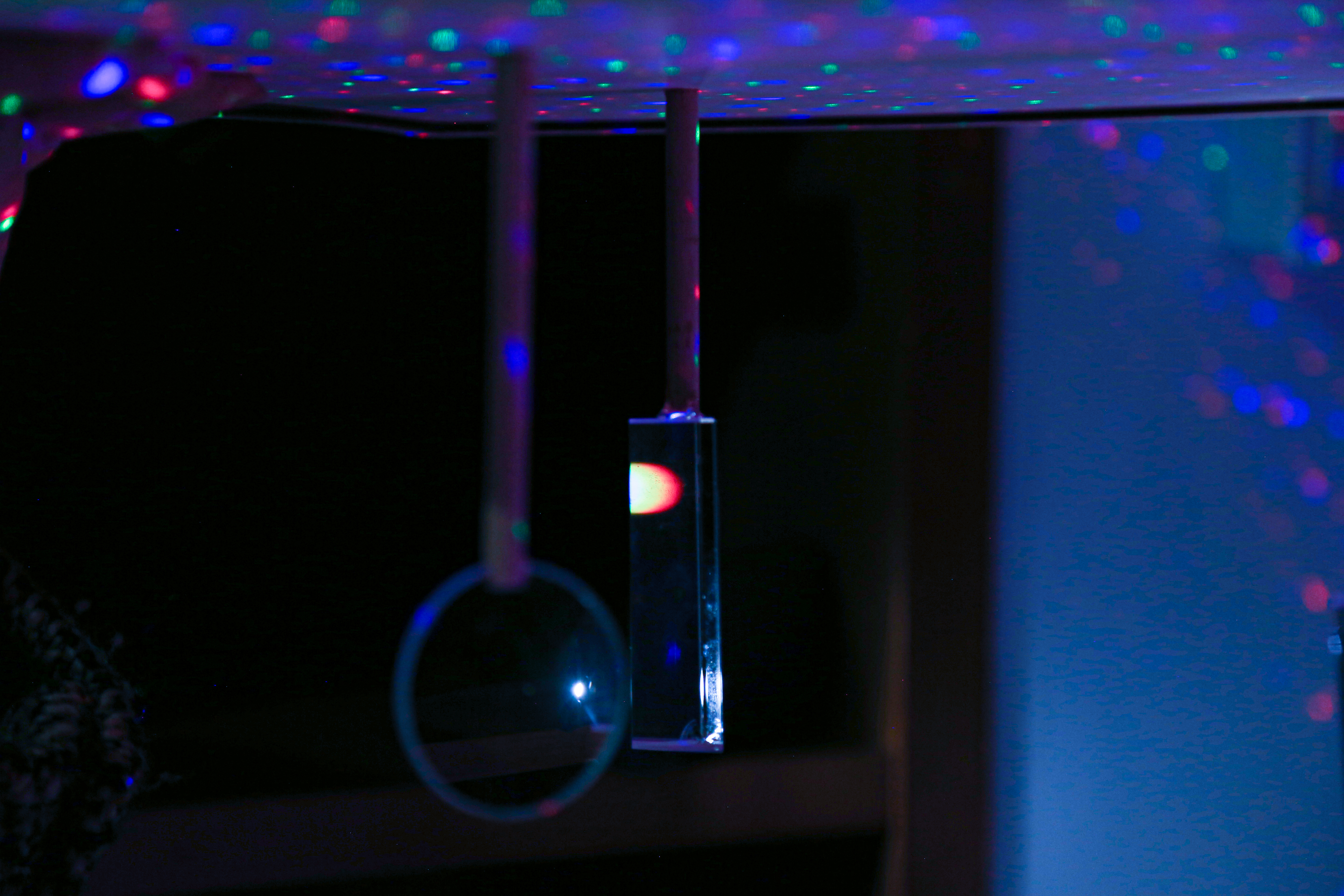 Hanging optical elements and colored light reflections in Nachtorchidee